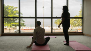 yoga moves from behind, ocean view outside of window